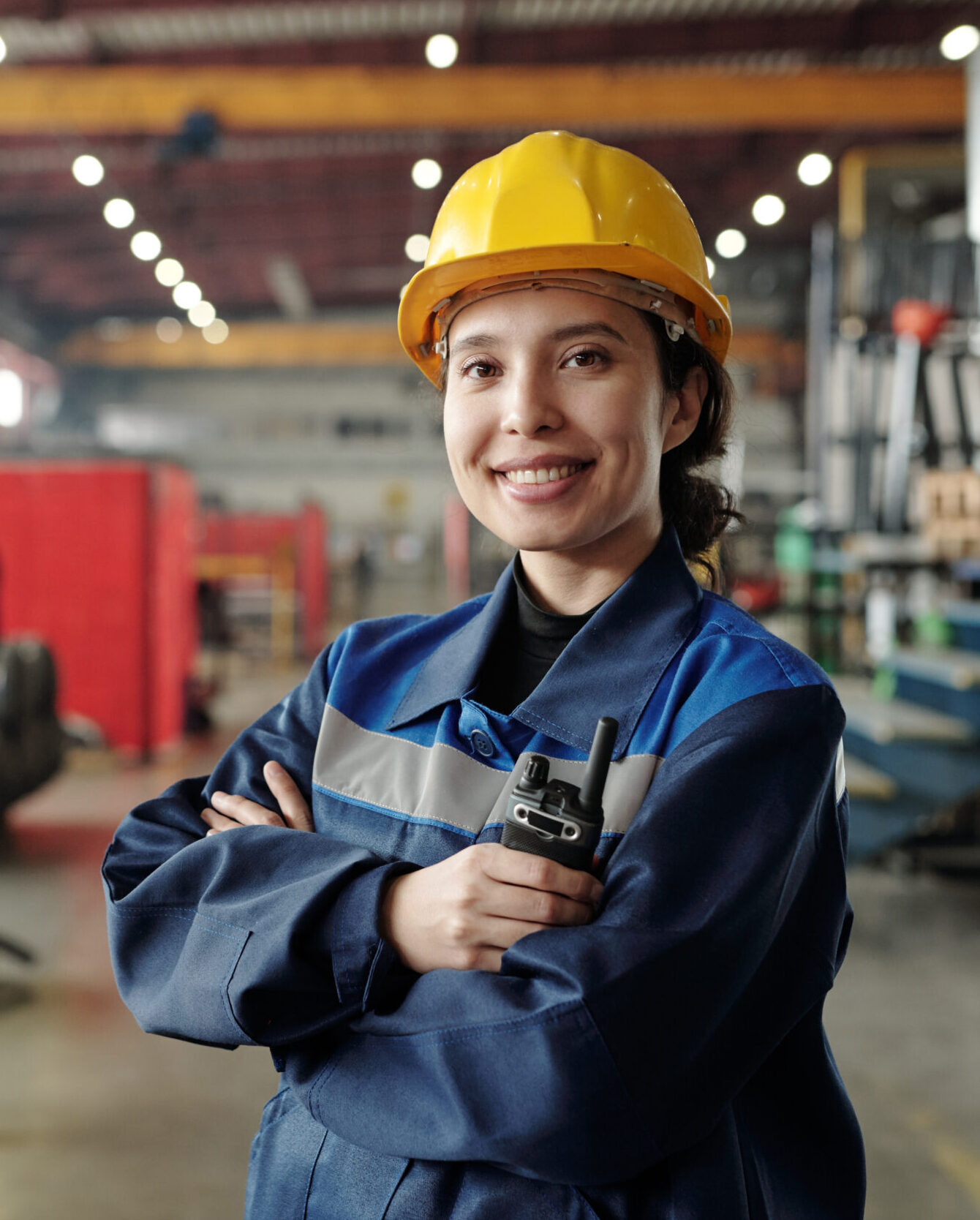 Young smiling female worker of modern industrial plant or factory in workwear and protective helmet agenzia per il lavoro AxL